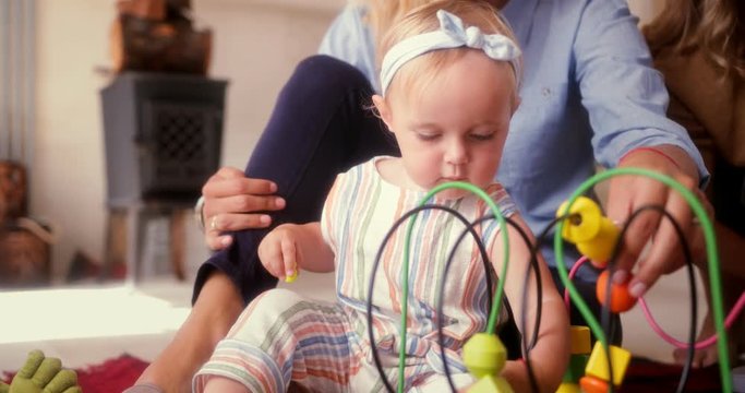 Girl with mother and grandmother playing with toys at home
