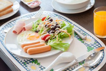 american breakfast on wood table.American breakfast with egg, sausage, bread and vegetable,Top view shot.