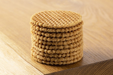 Wafers stacked in a pyramid on a wooden table. Copy space.