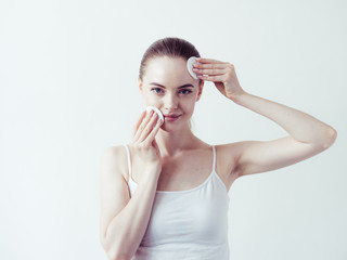 Obraz premium Woman makeup remove with cotton pad beauty healthy skin clean face