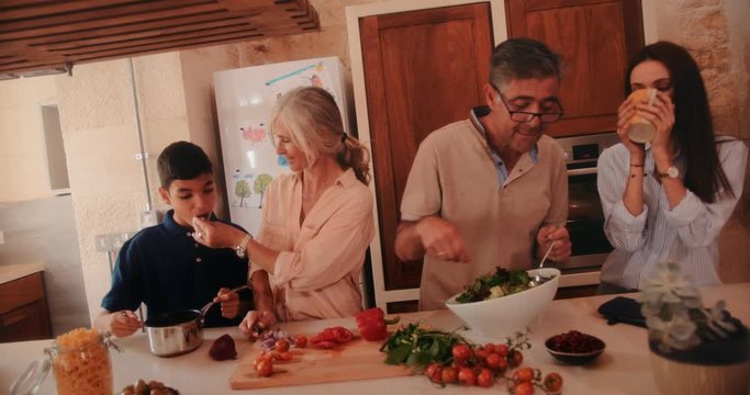 Happy three-generation family cooking healthy Mediterranean food at home