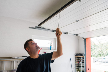man opens pvc garage door manually