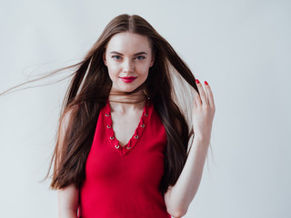 Beautiful woman brunette with long hair in red dress and red lipstick natural portrait