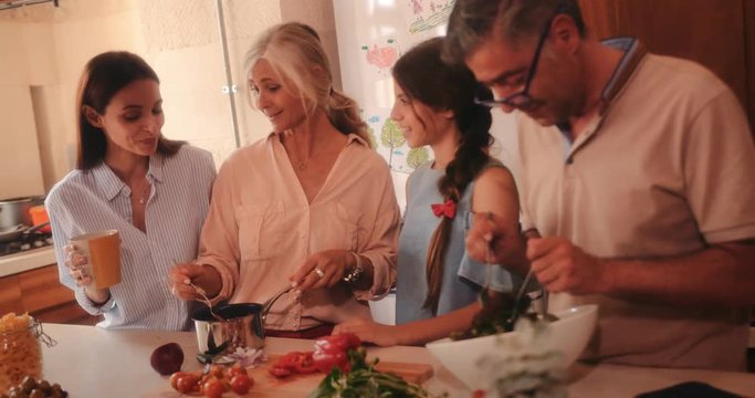 Family visiting grandparents and cooking healthy meal together