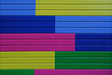 Colorful (yellow, green, blue and pink) painted wooden wall as background or texture