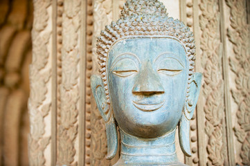 Fototapeta na wymiar Face of an ancient Buddha statue located outside of the Hor Phra Keo temple (former temple of the Emerald Buddha) in Vientiane, Laos.