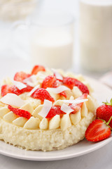 Delicate strawberry cheesecake with coconut. Delicious homemade cake with Fresh berries on light table.