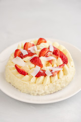 Delicate strawberry cheesecake with coconut. Delicious homemade cake with Fresh berries on light table.