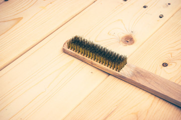 wire brush (brass) on wooden plank