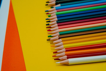 Color pencils on yellow background. Close up. Texture wood.