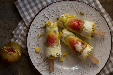 Milky ice cream pops made with fresh figs on a rustic wooden table. Summer lifestyle. Homemade healthy dessert. Close up, flat lay