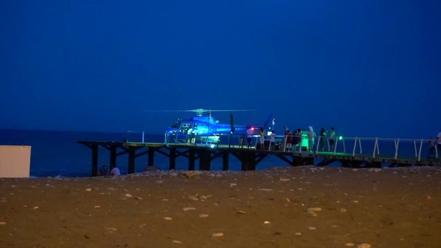 blue helicopter stands on the launch site and is getting ready for departure.