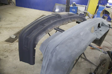 auto mechanic worker painting car in a paint chamber during repair work