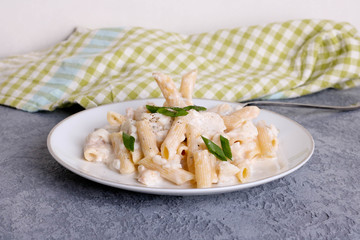 Delicious creamy Italian penne pasta on a white plate