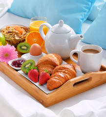 Breakfast tray in bed in hotel room