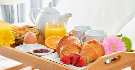 Breakfast tray in bed in hotel room