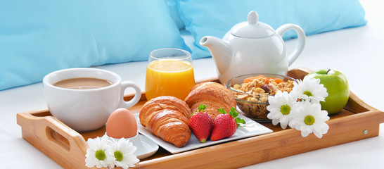 Breakfast tray in bed in hotel room