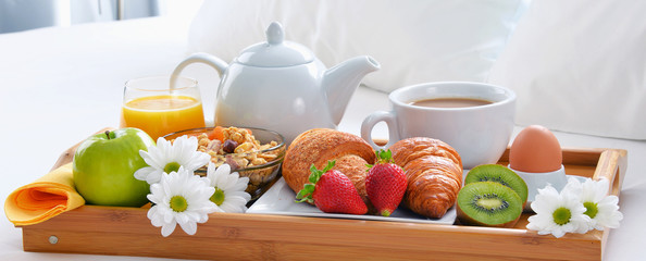 Breakfast tray in bed in hotel room
