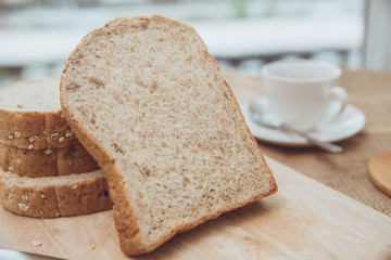 whole grain bread on wooden table morning meal with coffee vintage color tone
