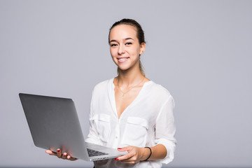 Portrait of confident intelligent woman using modern laptop for working isolated on gray background