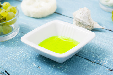 beauty product samples from grape seed ingredient, blue wooden table background, soft light