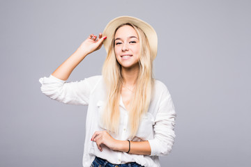 Portrait of a smiling young woman in hat looking away at copy space isolated over gray background