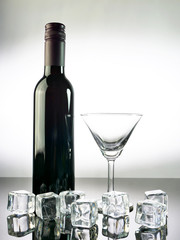 Wine bottle and glass of wine on table with white background.