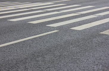 Crosswalk on City Street with Parallel Painted White Zebra Lines and Empty Asphalt Road Background. Pedestrian Cross Walk View with Traces from Wheel Tires at Crossing Point on City Street