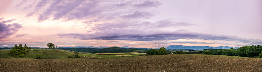 Fototapeta premium Rolling Landscape with Alps Mountains at Sunset.
