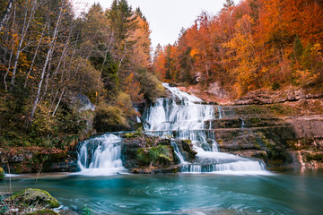 Rugged Waterfalls and River in Forest with Autumn Foliage.