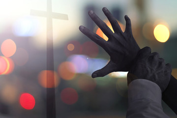 Halloween concept: scary hands stop people from looking for the cross