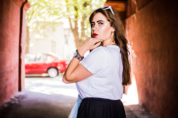 Fashionable and stylish girl in wide black pants, a white T-shirt with sunglasses with a white rim goes through the tunnels