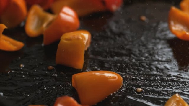 Stir frying orange and red bell pepper. Shot with high speed camera, phantom flex 4K. Slow Motion.