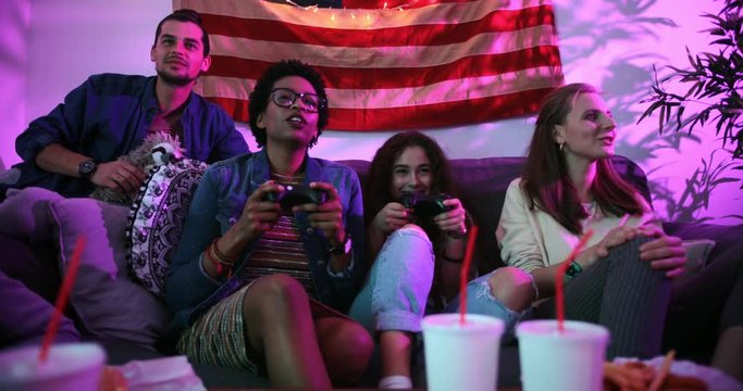 Multi-ethnic teenage friends having fun playing video games together
