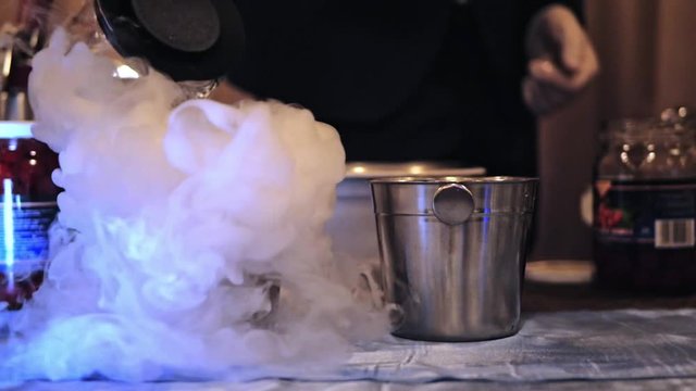 Preparation of cocktails with dry ice. Slow motion video. Clubs of steam from dry ice slowly diverge
