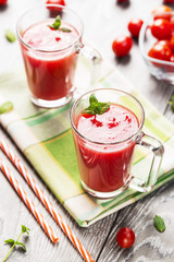 Beverages from tomato juice in glass mugs on table