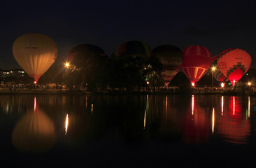 Fototapeta premium Hot air baloons flying in the evening sky near the lake