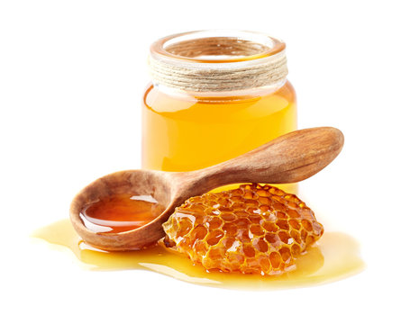 Naklejki Honey with honeycomb and wooden spoon