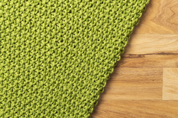 Close-up of knitted wool blanket on wooden background.