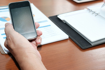 businessman use mobile phone at workplace. man holding smartphone for online connection.