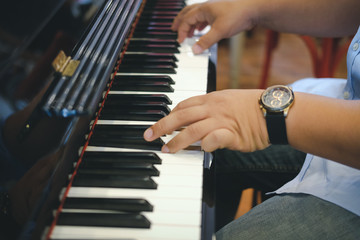 Obraz premium pianist man's hand playing piano. performer & classic music instrument