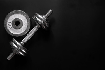 Dumbbell with black background.