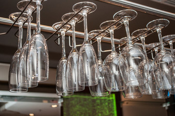 the concept of a holiday and a rest crystal clear glasses for a champagne wear above a bar rack