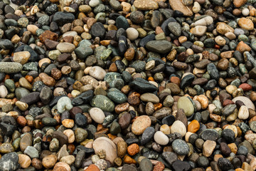 waves of the blue sea on a pebble beach. small pebble stones by the sea.