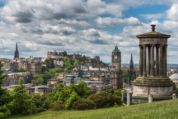 Edinburgh, Scotland, UK - June 13, 2012: Donald Stewart monument on Calton Hill with old town, castle, New College, Lloyds Banking group, Balmoral Clock tower, Scott Monument under heavy cloudscape.