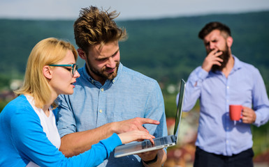 Colleagues working laptop, boss smoking while coffee break on background. Workaholics concept....