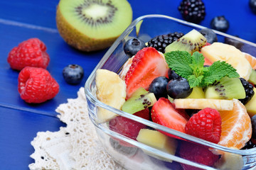 Bowl of healthy fresh fruit salad on wooden background