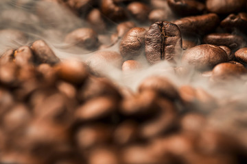 Close up pile of Coffee beans roasting with smoke