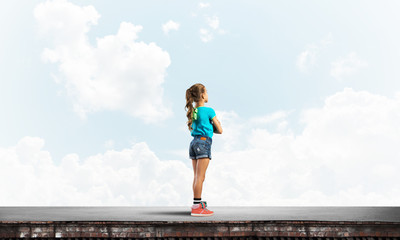 Concept of careless happy childhood with girl looking far away