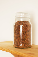 Buckwheat in a glass jar, isolated on a wooden board background and white background.